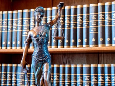 law figure justice statue in lawyer's office with bookshelf